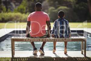 Father and son sitting together on bench