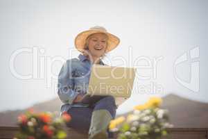 Smiling senior woman using laptop in park