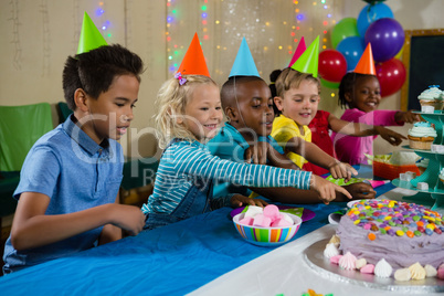 Kids pointing on cake