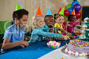 Kids pointing on cake