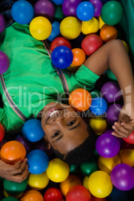 Overhead view of happy boy in ball pool