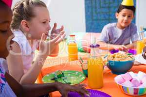 Children having food at table