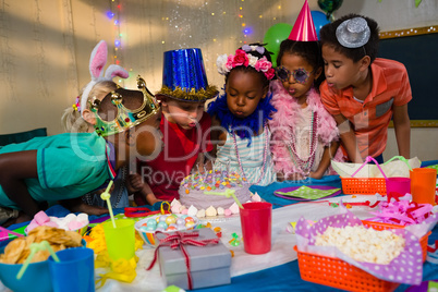 Children blowing candles on cake