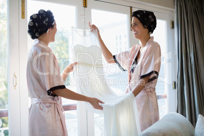Bride and her friend looking at wedding dress