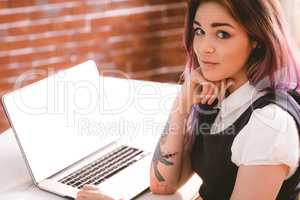Smiling woman sitting with laptop in office
