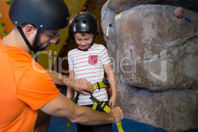 Trainer assisting boy to wear safety harness