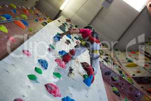 Teenage girl practicing rock climbing in fitness studio