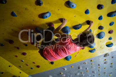 Teenage girl practicing rock climbing