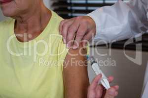 Physiotherapist injecting senior patient