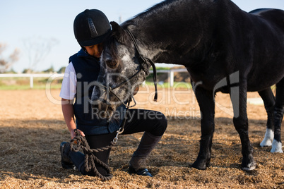 Rider boy caressing a horse in the ranch