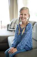 Smiling girl sitting on sofa in living room