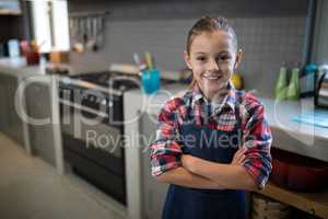 Smiling girl posing wearing an apron in the kitchen