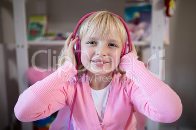 Cute girl listening to pink headphones