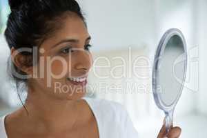 Smiling woman holding hand mirror