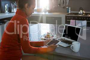 Young woman using tablet in kitchen
