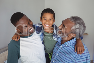 Smiling multi-generation family standing together in bedroom