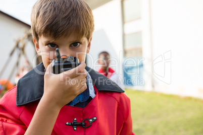Portrait of boy with face paint using walkie talkie