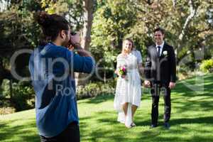 Photographer taking photo of newly married couple