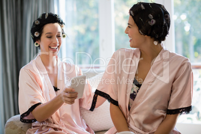 Bride and her friend using mobile phone
