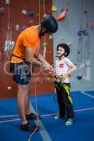 Trainer assisting boy to wear safety harness