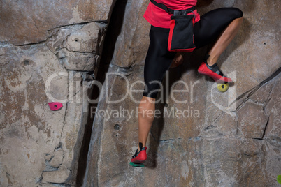 Low section of woman practicing rock climbing
