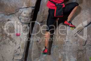 Low section of woman practicing rock climbing