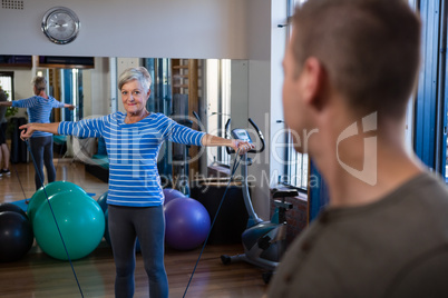 Smiling woman performing exercise with resistance band