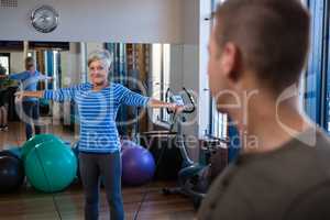 Smiling woman performing exercise with resistance band