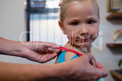 Physiotherapist sticking tape on girl patient