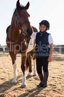 Rider boy caressing a horse in the ranch