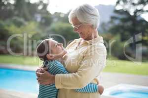 Granddaughter and grandmother embracing near the pool