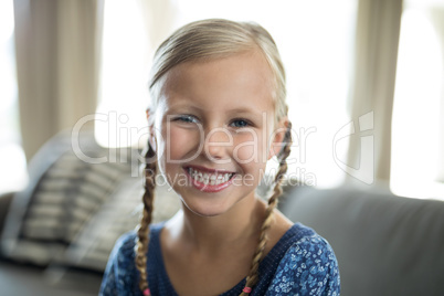 Smiling girl sitting on sofa in living room