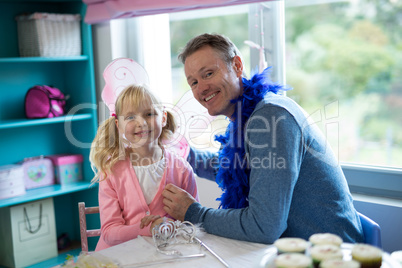 Girl pretending to be a fairy playing with her father