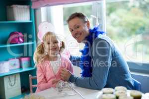 Girl pretending to be a fairy playing with her father