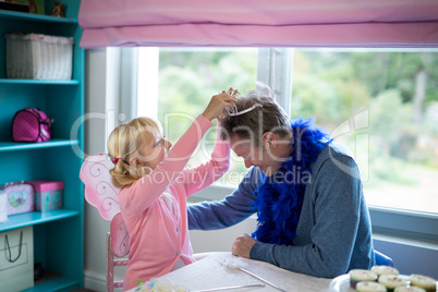 Girl pretending to be a fairy playing with her father