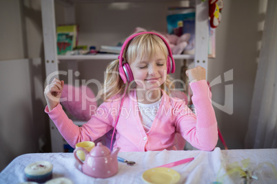 Cute girl listening to pink headphones