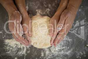 Grandmother and granddaughter holding dough in their hand