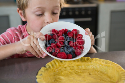 Boy preparing tart with berries