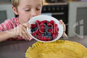 Boy preparing tart with berries