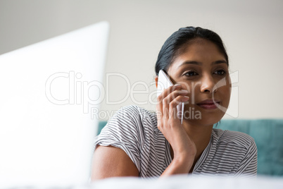 Woman with laptop talking on phone