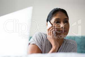 Woman with laptop talking on phone