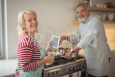 Smiling senior couple standing in kitchen