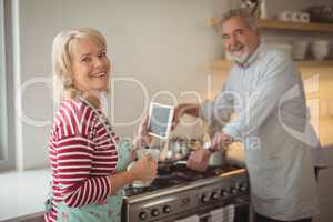 Smiling senior couple standing in kitchen