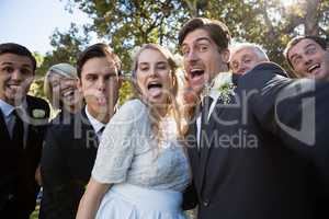 Happy couple posing with guests during wedding