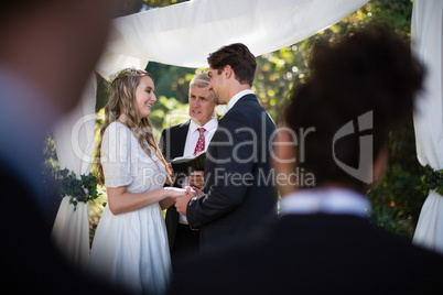 Minister giving speech to bride and groom