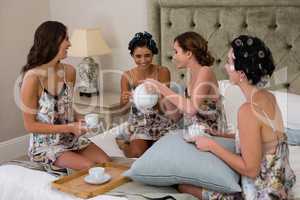 Women interacting while having a cup of tea