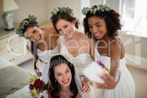 Bride and bridesmaid taking selfie at home