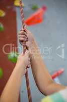 Boy practicing rope climbing in fitness studio