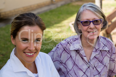 Portrait of smiling doctor with senior woman at yard