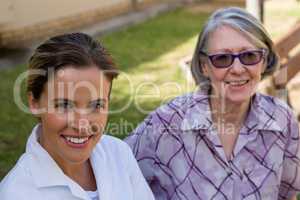Portrait of smiling doctor with senior woman at yard
